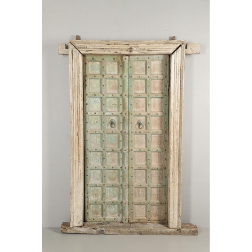 512 - A PAIR OF INDIAN PAINTED HARDWOOD DOORS. 20th century, each door panelled and metal studded with iro... 