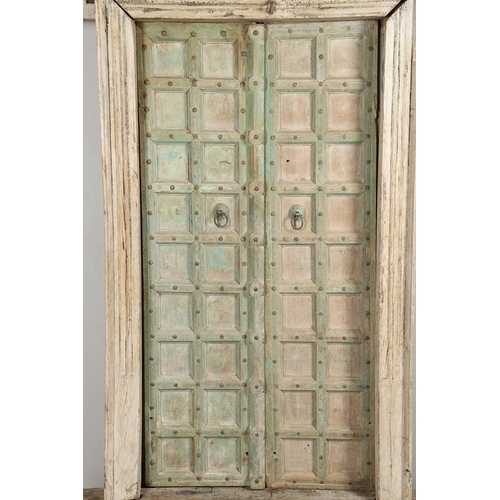 512 - A PAIR OF INDIAN PAINTED HARDWOOD DOORS. 20th century, each door panelled and metal studded with iro... 