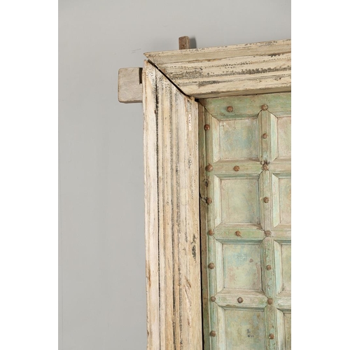 512 - A PAIR OF INDIAN PAINTED HARDWOOD DOORS. 20th century, each door panelled and metal studded with iro... 