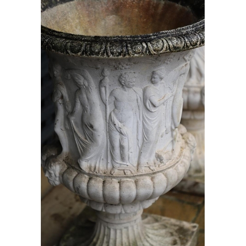 514 - A PAIR OF PAINTED COMPOSITE MARBLE MEDICI STYLE URNS. with relief classical decoration, on fluted so... 