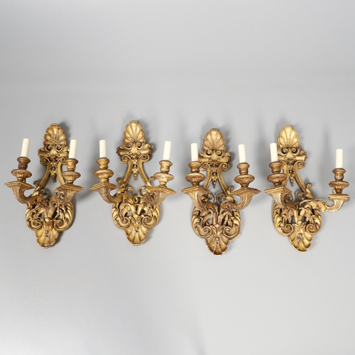 517 - A SET OF FOUR 19TH CENTURY GILT GESSO TWIN BRANCH WALL LIGHTS. with carved shell to crest and base t... 