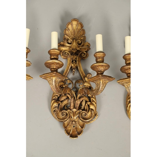 517 - A SET OF FOUR 19TH CENTURY GILT GESSO TWIN BRANCH WALL LIGHTS. with carved shell to crest and base t... 