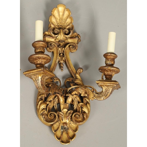 517 - A SET OF FOUR 19TH CENTURY GILT GESSO TWIN BRANCH WALL LIGHTS. with carved shell to crest and base t... 