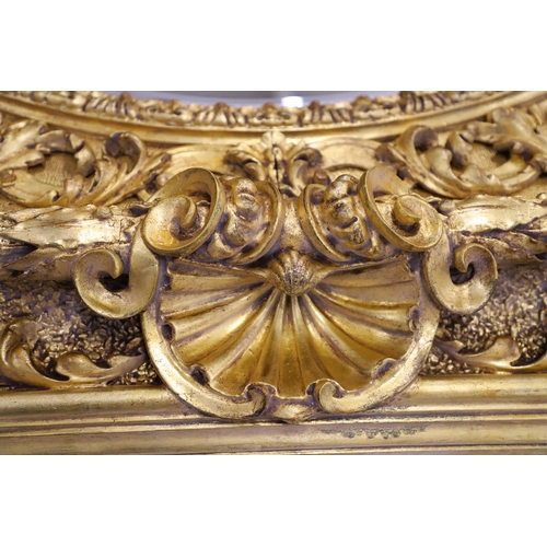 521 - A SUBSTANTIAL ITALIAN GILT GESSO MIRROR. early 20th century, the oval bevelled plate to a heavily mo... 