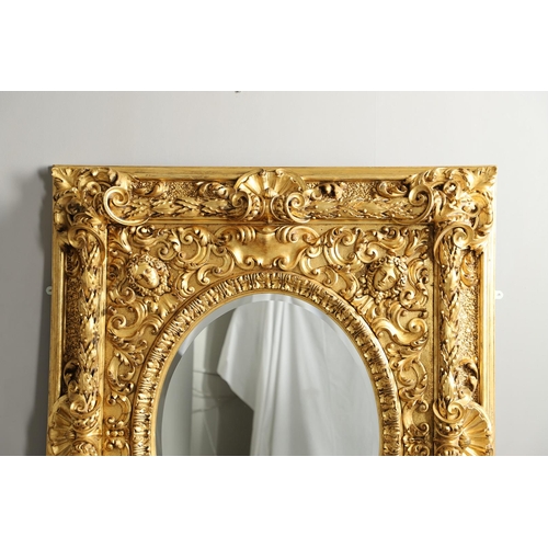 521 - A SUBSTANTIAL ITALIAN GILT GESSO MIRROR. early 20th century, the oval bevelled plate to a heavily mo... 