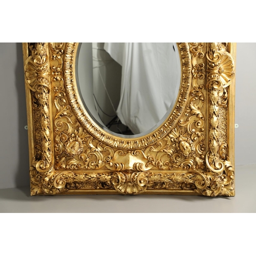 521 - A SUBSTANTIAL ITALIAN GILT GESSO MIRROR. early 20th century, the oval bevelled plate to a heavily mo... 