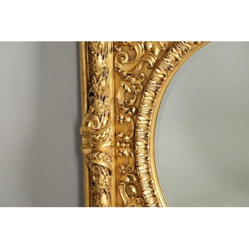 521 - A SUBSTANTIAL ITALIAN GILT GESSO MIRROR. early 20th century, the oval bevelled plate to a heavily mo... 