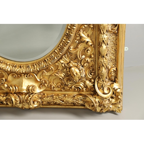 521 - A SUBSTANTIAL ITALIAN GILT GESSO MIRROR. early 20th century, the oval bevelled plate to a heavily mo... 