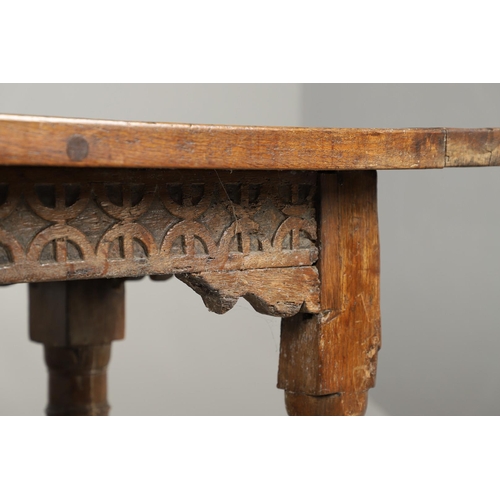 523 - A 17TH CENTURY AND LATER OAK REFECTORY TABLE. the four plank top over a carved frieze apron,  stretc... 