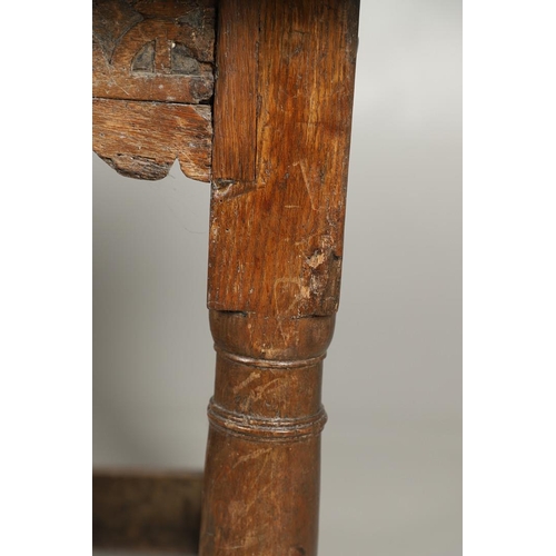 523 - A 17TH CENTURY AND LATER OAK REFECTORY TABLE. the four plank top over a carved frieze apron,  stretc... 