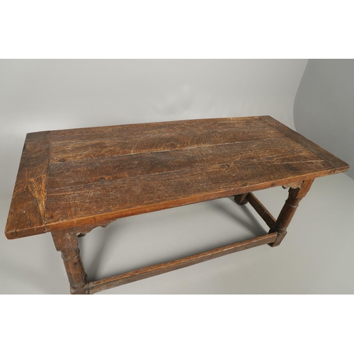 523 - A 17TH CENTURY AND LATER OAK REFECTORY TABLE. the four plank top over a carved frieze apron,  stretc... 