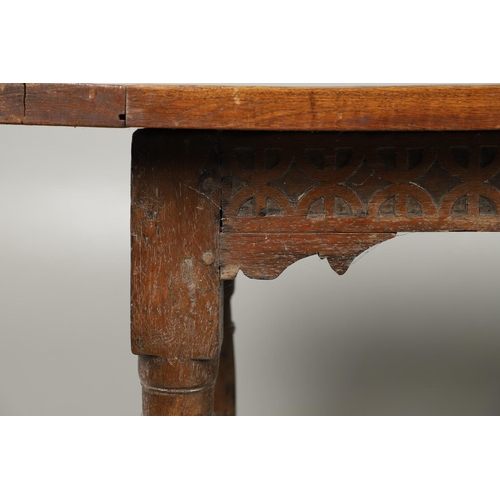 523 - A 17TH CENTURY AND LATER OAK REFECTORY TABLE. the four plank top over a carved frieze apron,  stretc... 