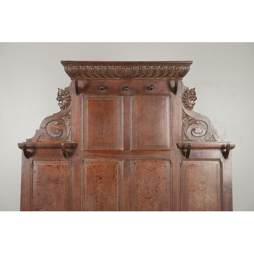 529 - A LARGE CARVED OAK COUNTRY HOUSE HALLSTAND. with a shaped cornice and panel back, carved Lion masks ... 