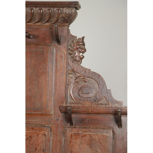 529 - A LARGE CARVED OAK COUNTRY HOUSE HALLSTAND. with a shaped cornice and panel back, carved Lion masks ... 