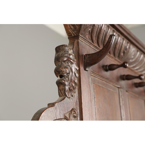 529 - A LARGE CARVED OAK COUNTRY HOUSE HALLSTAND. with a shaped cornice and panel back, carved Lion masks ... 