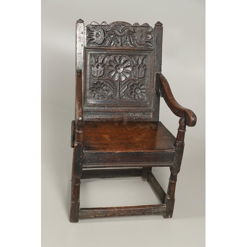 530 - A 17TH CENTURY OAK WAINSCOTT CHAIR. the back with relief-carved frieze and panel of multiple flowers... 