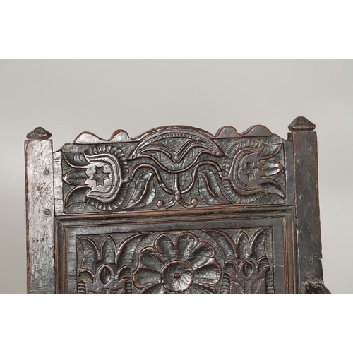 530 - A 17TH CENTURY OAK WAINSCOTT CHAIR. the back with relief-carved frieze and panel of multiple flowers... 