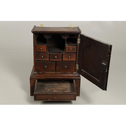 532 - A 17TH CENTURY OAK SPICE CUPBOARD. the panelled door revealing a pigeon hole interior and seven smal... 