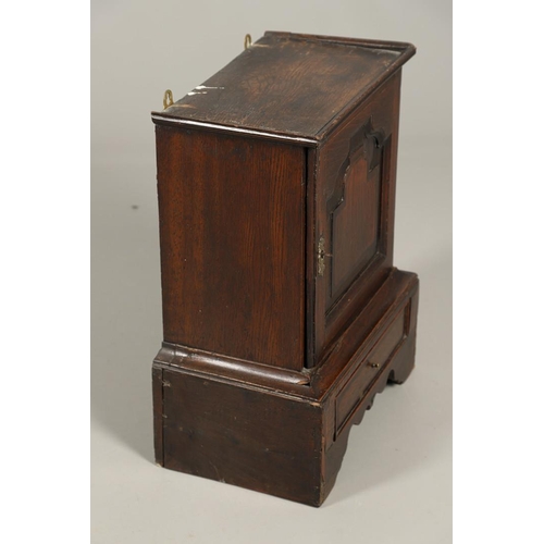 532 - A 17TH CENTURY OAK SPICE CUPBOARD. the panelled door revealing a pigeon hole interior and seven smal... 