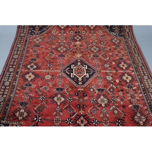 547 - A MODERN KASHGAI RUG. the raspberry lozenge field of stylised plants around an indigo diamond medall... 