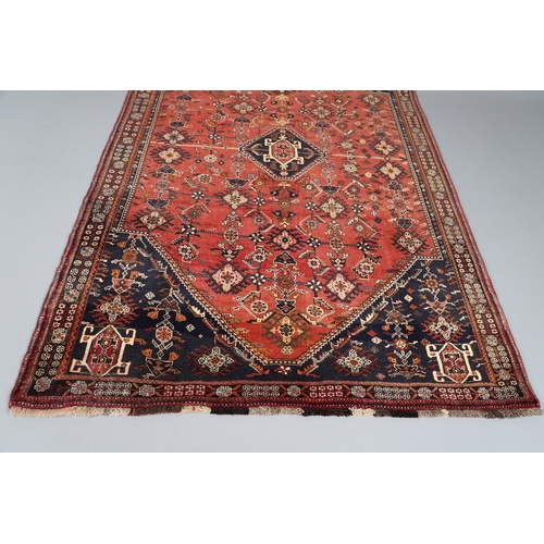 547 - A MODERN KASHGAI RUG. the raspberry lozenge field of stylised plants around an indigo diamond medall... 