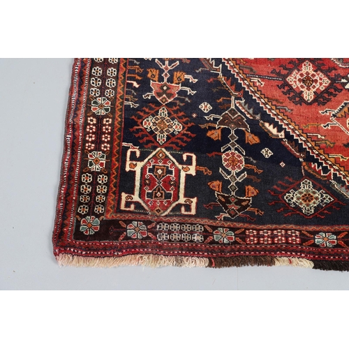 547 - A MODERN KASHGAI RUG. the raspberry lozenge field of stylised plants around an indigo diamond medall... 