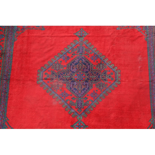 548 - A MAPLES 'TURKEY' CARPET, WEST ANATOLIA, CIRCA 1920. the tomato red field centred by a hexagonal dia... 