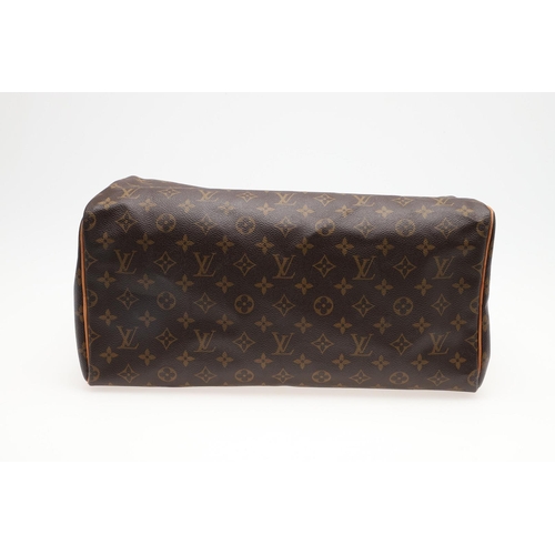 555 - LOUIS VUITTON 'SPEEDY' HANDBAG. A monogrammed and leather handbag with pouch to the interior, with a... 