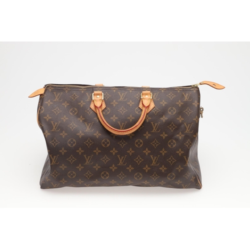 555 - LOUIS VUITTON 'SPEEDY' HANDBAG. A monogrammed and leather handbag with pouch to the interior, with a... 