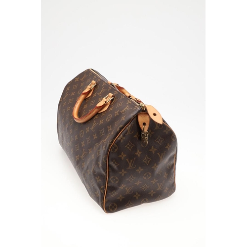 555 - LOUIS VUITTON 'SPEEDY' HANDBAG. A monogrammed and leather handbag with pouch to the interior, with a... 