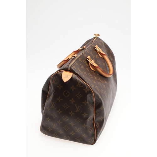 555 - LOUIS VUITTON 'SPEEDY' HANDBAG. A monogrammed and leather handbag with pouch to the interior, with a... 