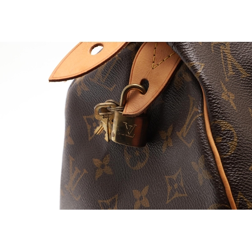 555 - LOUIS VUITTON 'SPEEDY' HANDBAG. A monogrammed and leather handbag with pouch to the interior, with a... 