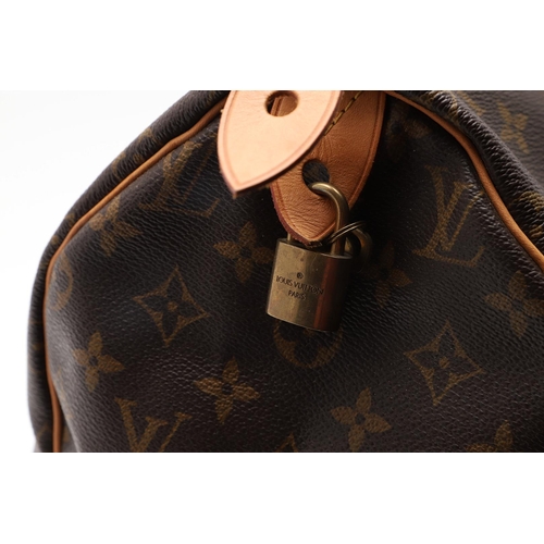 555 - LOUIS VUITTON 'SPEEDY' HANDBAG. A monogrammed and leather handbag with pouch to the interior, with a... 