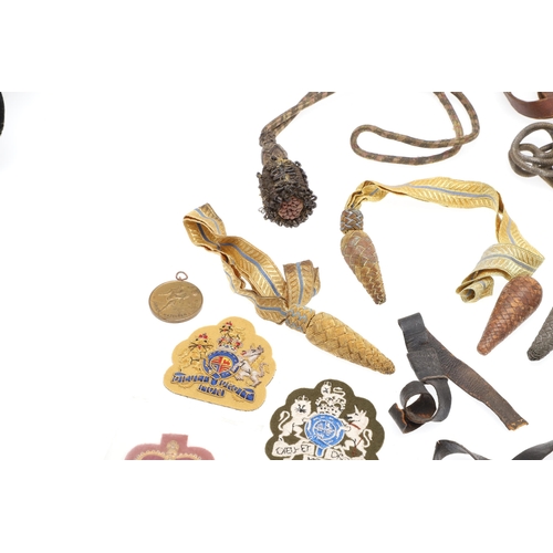 121 - A COLLECTION OF SWORD KNOTS AND MILITARY BADGES. A collection of nine sword knots, various patterns ... 