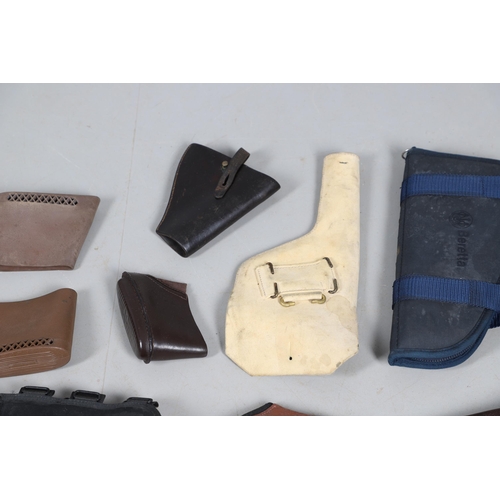 15 - A BROWN LEATHER PISTOL HOLSTER AND OTHERS SIMILAR. A brown leather pistol holder and a selection of ... 