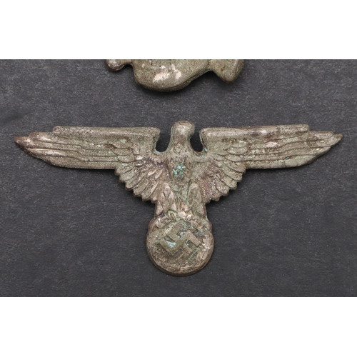 219 - A SECOND WORLD WAR GERMAN SS PEAKED CAP INSIGNIA SET. An insignia set comprising zinc eagle with wid... 