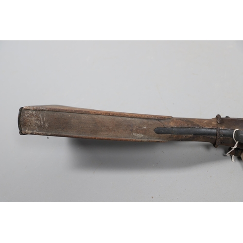 35 - A FLINTLOCK LONG GUN IN RELIC CONDITION AND SIMILAR SWORD. A flintlock gun with a 129 cm barrl, remn... 