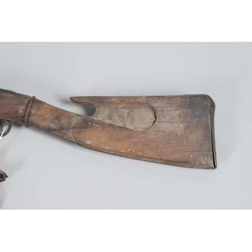 35 - A FLINTLOCK LONG GUN IN RELIC CONDITION AND SIMILAR SWORD. A flintlock gun with a 129 cm barrl, remn... 