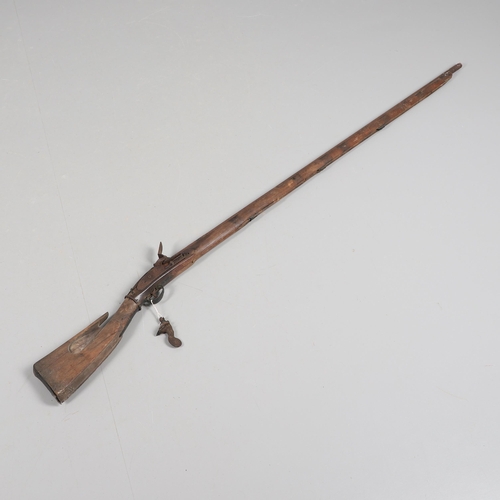 35 - A FLINTLOCK LONG GUN IN RELIC CONDITION AND SIMILAR SWORD. A flintlock gun with a 129 cm barrl, remn... 