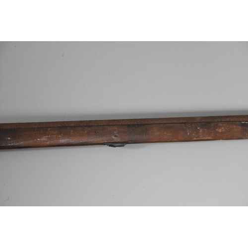 35 - A FLINTLOCK LONG GUN IN RELIC CONDITION AND SIMILAR SWORD. A flintlock gun with a 129 cm barrl, remn... 