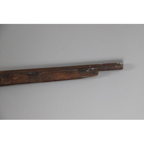 35 - A FLINTLOCK LONG GUN IN RELIC CONDITION AND SIMILAR SWORD. A flintlock gun with a 129 cm barrl, remn... 