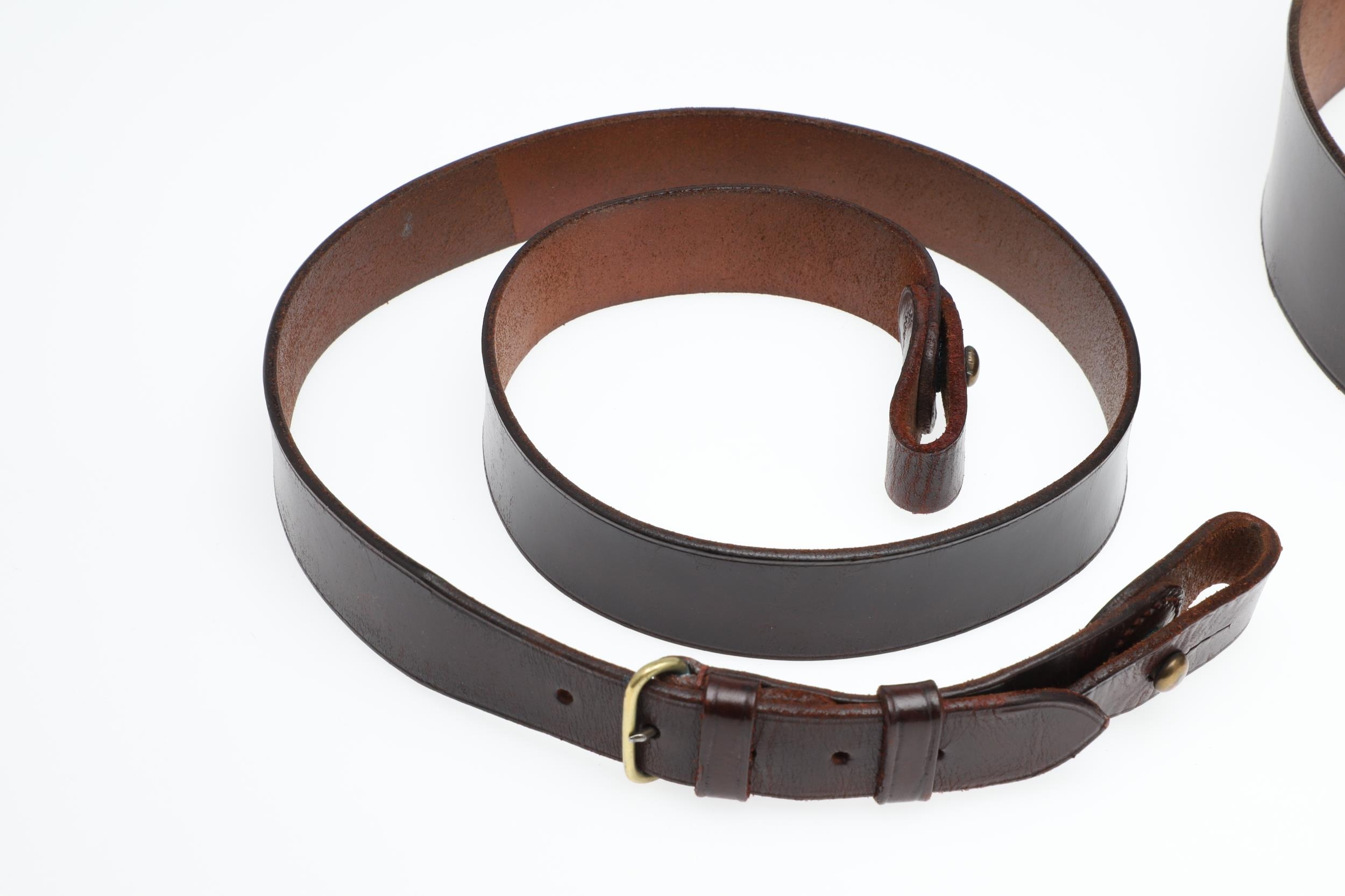 AN OFFICER'S BROWN LEATHER 'SAM BROWNE' BELT AND A SERVICE SCABBARD. A