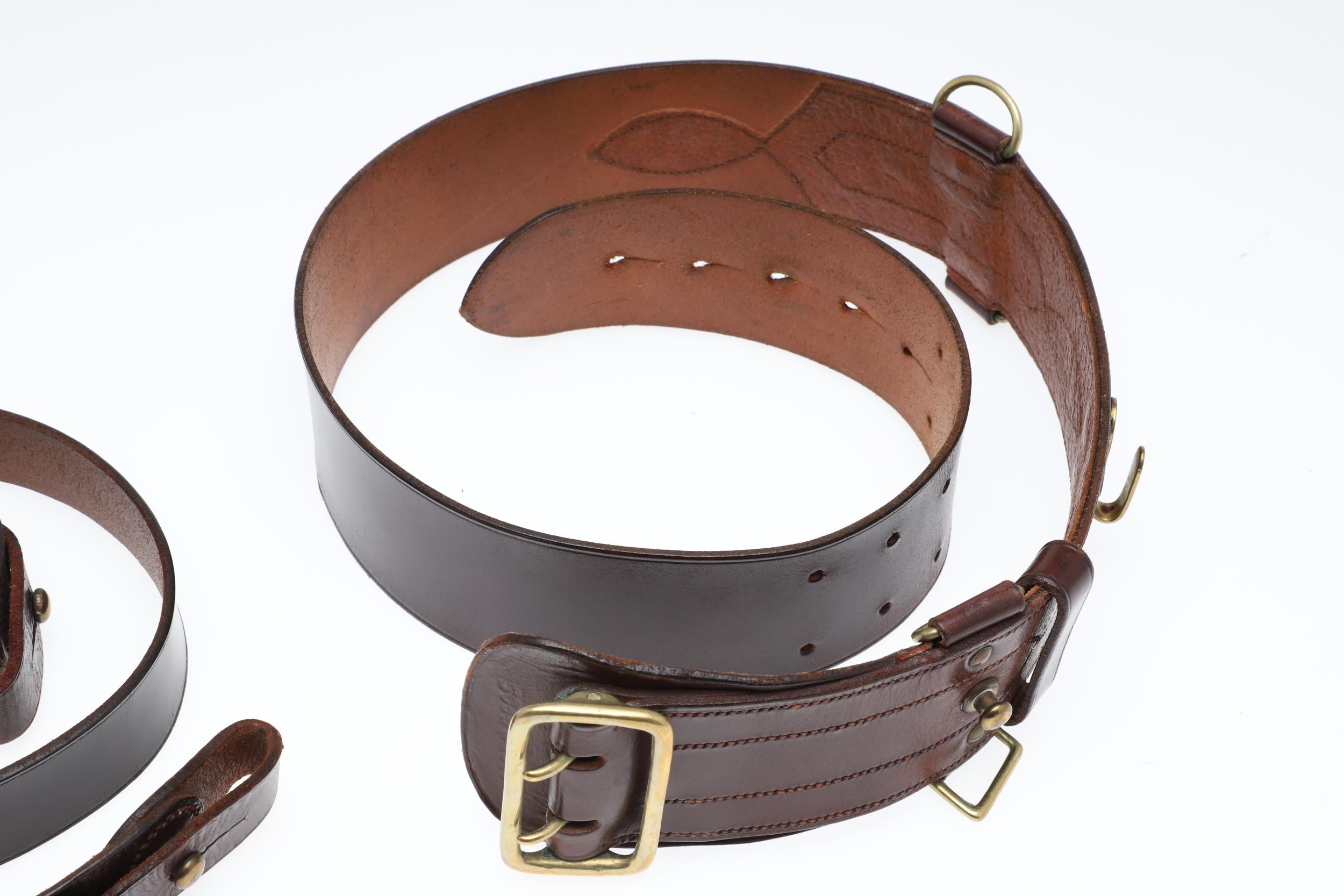 AN OFFICER'S BROWN LEATHER 'SAM BROWNE' BELT AND A SERVICE SCABBARD. A