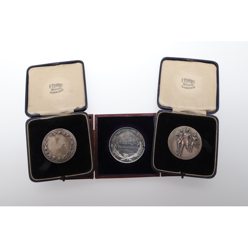 475 - A SILVER PRESENTATION MEDAL FROM THE CONFECTIONERS AND BAKERS EXHIBITION AND TWO OTHERS. A silver aw... 