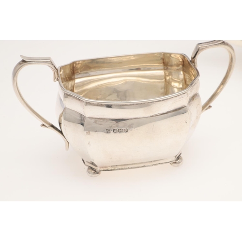 120 - A GEORGE V THREE-PIECE SILVER TEA SET. shaped rectangular form, with angular handles and on bun feet... 