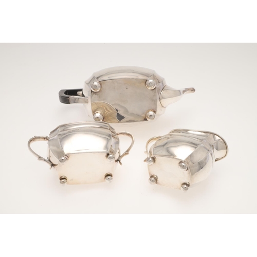 120 - A GEORGE V THREE-PIECE SILVER TEA SET. shaped rectangular form, with angular handles and on bun feet... 