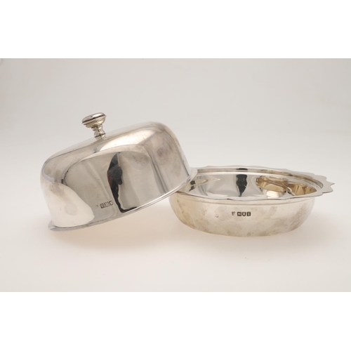 122 - AN EDWARDIAN SILVER MUFFIN DISH & COVER. shaped circular outline, with a wavy rim & a knop finial, b... 