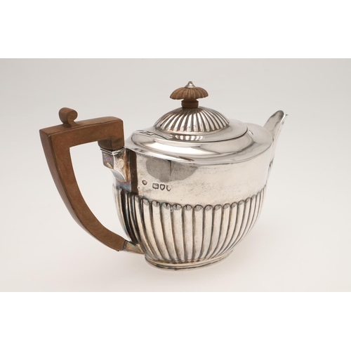 126 - A LATE VICTORIAN THREE-PIECE SILVER TEA SET. of oval outline, with angular handles and part-fluted b... 