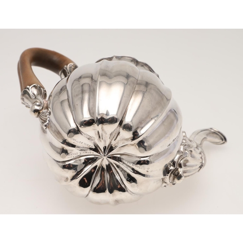 129 - A GEORGE IV SILVER COFFEE POT. of melon fluted form, with a scroll handle and  a shell-capped spout,... 