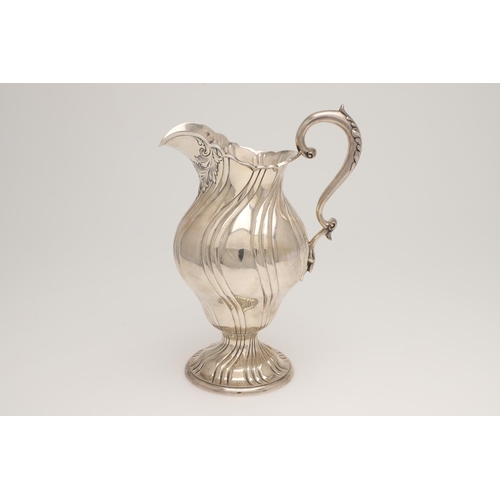 141 - A LATE 19TH/ EARLY 20TH CENTURY NORTH-AMERICAN SILVER JUG. with a bellied body, a leaf-capped 'S'-sc... 